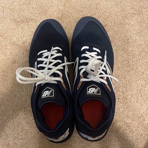 Navy blue New Balance metal spikes (baseball cleats).